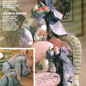 May include: McCall's Crafts pattern 6557 features instructions for creating fabric cat figures. The pattern includes instructions for a large cat, approximately 13 inches (33 cm) tall, and a smaller cat, about 8 inches (20 cm) tall. The image shows examples of the finished cat designs.