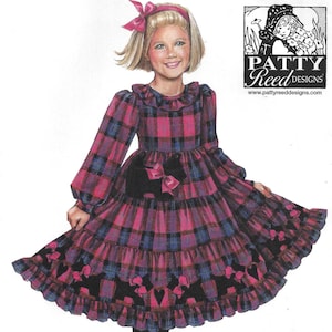 May include: Simplicity sewing pattern 2776 for a girl's dress. The dress features a plaid design in shades of pink, blue, and black. The pattern includes sizes 3, 4, 5, 6, 7, and 8. The dress has long sleeves and a tiered skirt.