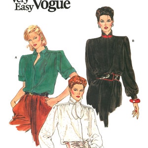 May include: A sewing pattern featuring three different blouse designs. The first blouse is green with puffed shoulders, the second is black with a high collar, and the third is white with a bow tie. The pattern is titled "Very Easy Vogue".