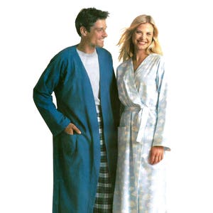 May include: A man and woman are shown wearing sleepwear. The man is wearing a teal robe and plaid pajama pants. The woman is wearing a light blue robe with a floral pattern and matching pajama pants. Both are smiling.