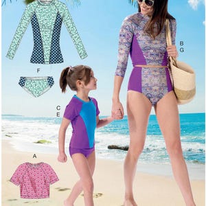 May include: McCall's M7417 sewing pattern for kids' swimwear. The pattern includes various swimsuits with different designs and sleeve lengths. The image shows a woman and a child wearing the swimsuits on a beach. Sizes 3-4, 5-6, and 7-8.