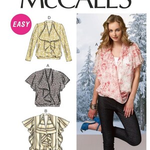 May include: A sewing pattern for a women's blouse with a ruffled neckline and long or short sleeves. The pattern includes four different styles: a long-sleeved blouse with a floral print, a short-sleeved blouse with a leopard print, a short-sleeved blouse with a striped print, and a long-sleeved blouse with a paisley print. The pattern is labeled "McCall's Easy".