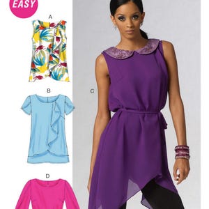 May include: McCall's sewing pattern featuring a woman in a purple top with a decorative collar and a belt. The pattern also shows three other top designs: a floral print top, a blue top with a ruffle, and a pink top with long sleeves.
