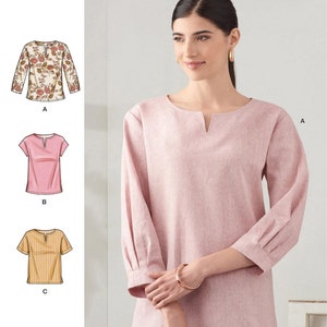 May include: Simplicity sewing pattern S9274 for a top with a notched neckline. The pattern includes three variations: a floral print long-sleeve top, a solid pink short-sleeve top, and a striped short-sleeve top. The main image shows a solid pink top.