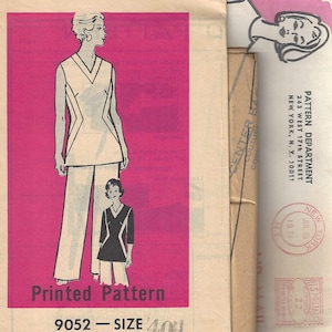 May include: Vintage sewing pattern packet featuring a fashion illustration of a woman in a tunic and pants. The packet has a pink background with the text "Printed Pattern" and "9052 - SIZE 40". Additional packets are visible.