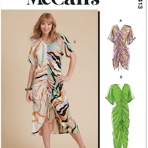 May include: A sewing pattern for a dress with three different view options. The dress has a gathered bodice and a flowing skirt. The pattern is printed in the USA.