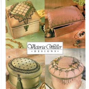 May include: Four different sewing patterns for decorative boxes. The boxes are made of fabric and have intricate beading and embroidery. The patterns are from Vogue Crafts and Victoria Waller Designs.