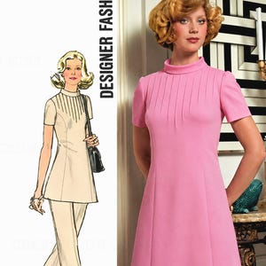 May include: A sewing pattern illustration showing a tunic and trousers alongside a photograph of a pink knee-length dress with a high collar and vertical pleats at the chest. The text DESIGNER FASHION is printed vertically on the left side.
