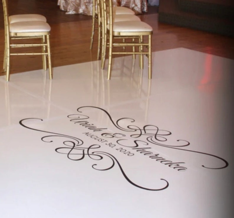 May include: White dance floor with a black and white custom design that says "[Name] & [Name] August 30, 2020".