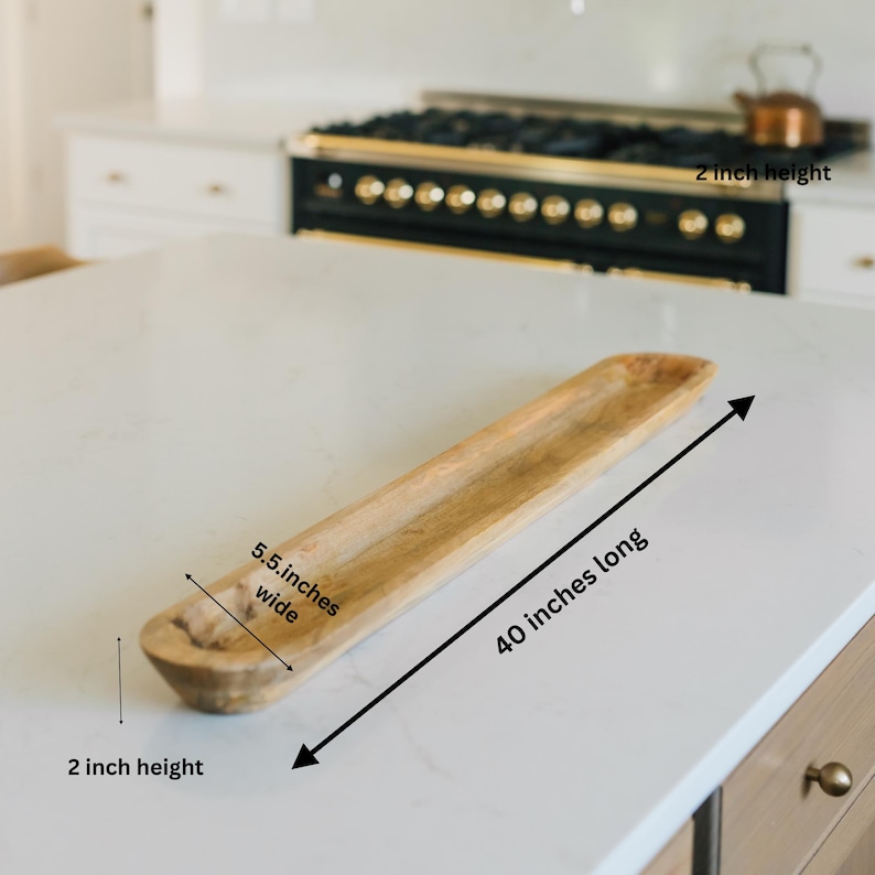 May include: A long, rectangular wooden bowl, 40 inches long, 5.5 inches wide, and 2 inches high. The natural wood grain is visible. The bowl is on a white countertop, suggesting kitchen or dining use.