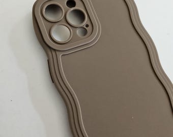 May include: A brown phone case with a wavy design and a raised camera lens cutout.