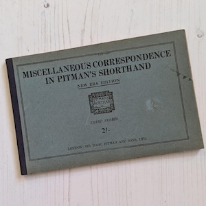 May include: A green book titled "Miscellaneous Correspondence in Pitman's Shorthand" with the words "New Era Edition" and "Third Series" printed on the cover. The book is priced at 2/-.
