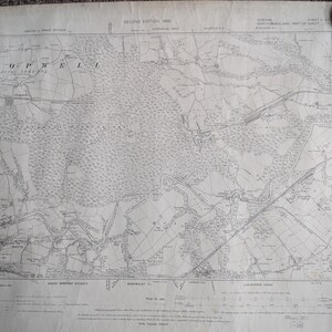 May include: A vintage black and white topographical map titled Second Edition 1898, featuring the Chopwell area. The detailed paper document displays intricate land contours, railway lines, and geographical markings across the landscape.