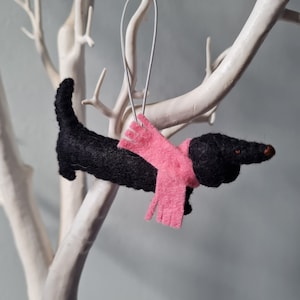 Zwarte teckel, worsthonddecoratie. Hangende hondendecoratie van wolvilt voor de kerstboom. Handgemaakte decoratie, kerstboomornament.