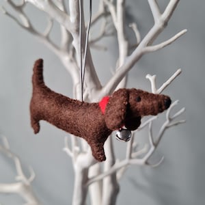Bruine teckel, worsthonddecoratie. Hangende hondendecoratie van wolvilt voor in de kerstboom. Handgemaakte decoratie, kerstboomornament.