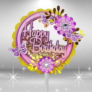 Puede incluir: Un adorno para pastel rosa y dorado con las palabras "Happy Birthday" en purpurina rosa. El adorno presenta mariposas, flores y lentejuelas.