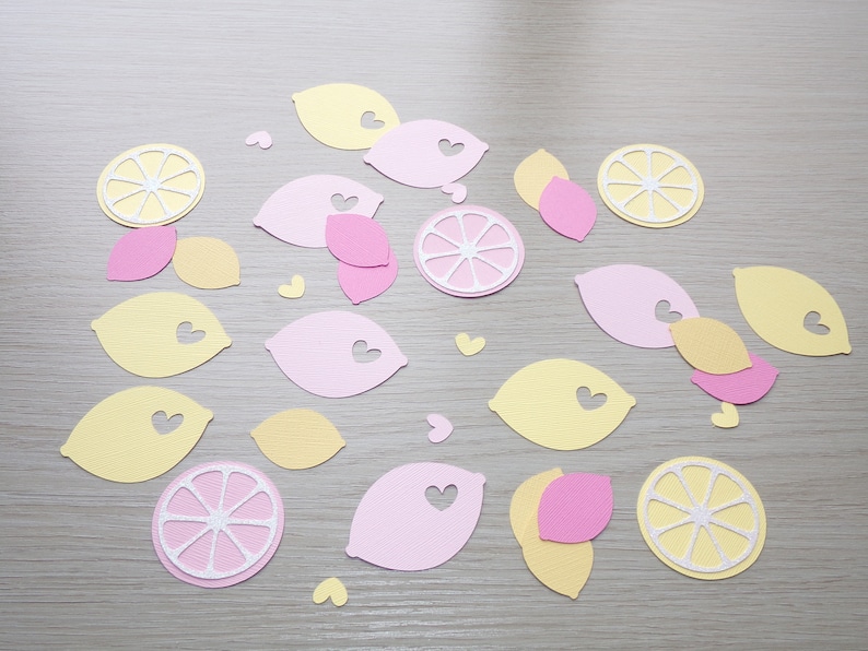 Puede incluir: Una colecci&oacute;n de recortes de papel con forma de limones y corazones. Los recortes son en tonos amarillos, rosas y blancos.