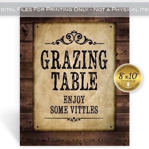 May include: Printable sign with a rustic wood background and a vintage paper texture. The sign says "Grazing Table Enjoy Some Vittles" in black text with a decorative flourish. The sign is 8 inches by 10 inches.