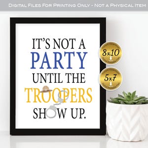 May include: Black framed print with the text "IT'S NOT A PARTY UNTIL THE TROOPERS SHOW UP." The text is in black, blue, and yellow. The image includes a hat and handcuffs graphic. Two gold circular stickers are in the upper right corner.