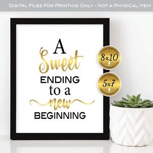 May include: A black framed printable sign with gold lettering that reads "A Sweet Ending to a New Beginning". The sign is displayed on a white surface with a small potted plant in the corner. The sign is available in two sizes: 8x10 inches and 5x7 inches.