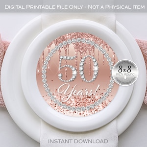 May include: A printable 8x8 inch round digital file featuring a pink and white design with the number 50 and the words "Years!" surrounded by a diamond-like border. The design is on a white plate with a pink napkin.