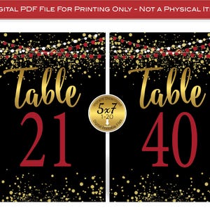 May include: Black digital printable table numbers. The numbers 21 and 40 are in red, with the word "Table" in gold script. The background is black with gold confetti and red and gold string lights.