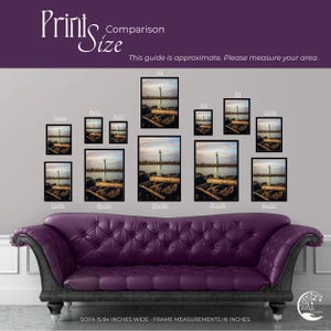 a purple couch sitting in front of a wall with pictures on it