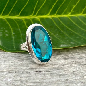 Puede incluir: Un anillo de plata con una gran piedra preciosa ovalada de color azul turquesa.