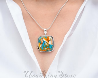 May include: A silver chain necklace with a square pendant featuring a colorful turquoise and orange stone.