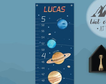 May include: A blue and white growth chart featuring a space theme with planets and stars. The chart is personalized with the name "LUCAS" and includes a scale from 2 to 60 inches.