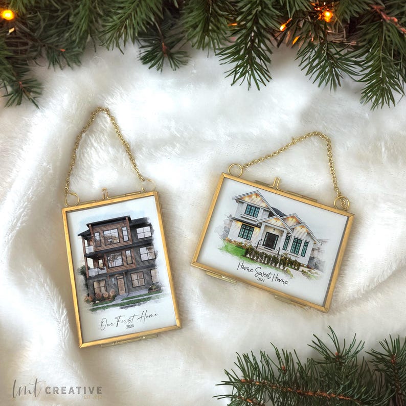 May include: Two gold-framed house-shaped Christmas ornaments. Each ornament features a watercolor-style illustration of a house and text. One ornament says 'Our First Home 2024.' The other says 'Home Sweet Home 2024.'  Both ornaments hang from gold chains.