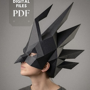 May include: A black geometric paper mask with sharp angles and a pointed beak, worn by a person. The mask is a digital PDF file. The image includes the text "DIGITAL FILES PDF" and the logo "simaga PAPER & WOOD".