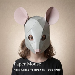 Peut inclure: Un masque de souris en papier géométrique avec un design à facettes gris clair, de grandes oreilles aux tons roses et un petit nez rose. Le texte smagapaperwood, Paper Mouse et PRINTABLE TEMPLATE SVG+PDF est visible sur l'image.