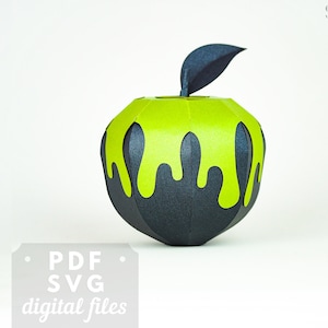 Puede incluir: Una manzana de papel negro y verde con una sustancia verde que gotea. La manzana es un modelo 3D y tiene una hoja en la parte superior. El texto "PDF SVG digital files" está en la parte inferior de la imagen.