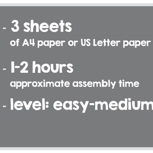 Peut inclure: Un fond gris avec du texte blanc d&eacute;crivant les mat&eacute;riaux et le temps d'assemblage d'un projet de papercraft. Le texte indique&nbsp;: - 3 feuilles de papier A4 ou de papier US Letter - 1 &agrave; 2&nbsp;heures de temps d'assemblage approximatif - niveau&nbsp;: facile &agrave; moyen