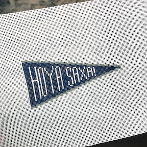 May include: A white canvas with a blue pennant that says "HOYA SAXA!" in white lettering.