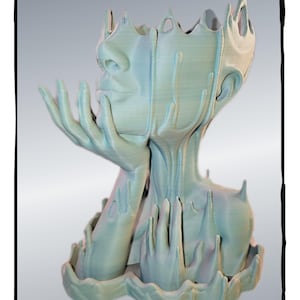 May include: A light blue, 3D printed planter shaped like a human head with a crown of thorns. The head is tilted back and the hands are clasped together in front of the face. The planter is designed to hold small plants or flowers.
