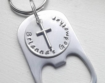 May include: Silver bottle opener keychain with a cross charm and the text "God's Gift" and "Brianna's" engraved on the front.