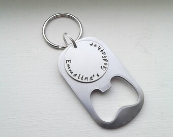 May include: Silver bottle opener keychain with a round tag that says "Emmalina's" and a smaller round tag that says "Joyful Godmother".