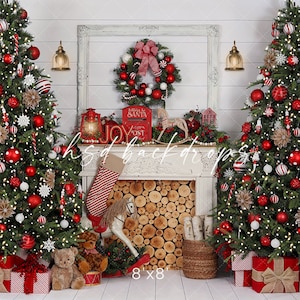 May include: A Christmas-themed backdrop with two decorated trees, red baubles, and fairy lights. A fireplace with a log-filled hearth is central, decorated with a stocking, rocking horse, and a wreath. The backdrop includes the text "hsd backdrops" and "8'x8'".
