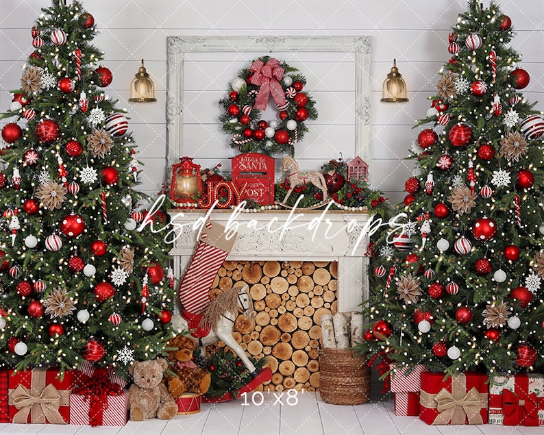 May include: A Christmas-themed backdrop with two decorated trees adorned with red and white baubles, lights, and presents. A fireplace with a wreath, lantern, and stocking is in the centre. The text "hsd backdrops" and "10'x8'" are visible.