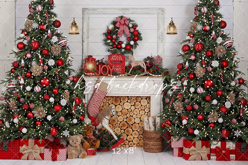 May include: A Christmas-themed backdrop with two decorated trees adorned with red baubles, white lights, and decorative elements. A fireplace mantel displays a wreath, lanterns, and a stocking. The scene includes wrapped gifts and a rocking horse.