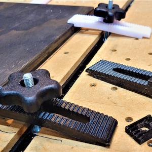 Puede incluir: Tres abrazaderas de plástico negro con una perilla en forma de estrella para apretar. Las abrazaderas están diseñadas para la carpintería y tienen una superficie acanalada para un mejor agarre.