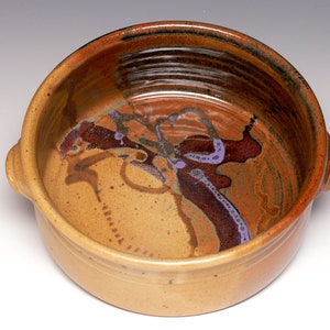 May include: A brown ceramic baking dish with two handles. The dish has a mottled glaze with brown, orange, and purple accents.