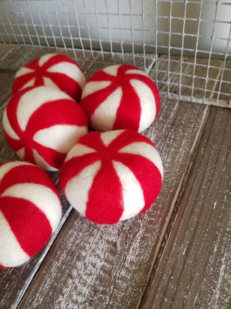 K&ouml;nnte beinhalten: F&uuml;nf rote und wei&szlig;e Pfefferminzbonbon-f&ouml;rmige Ornamente aus Filz.