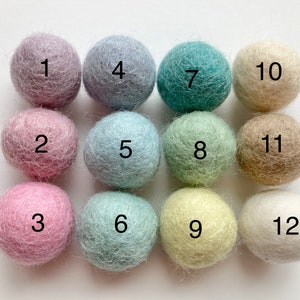 May include: Twelve felt balls in various pastel colors, numbered 1 through 12.