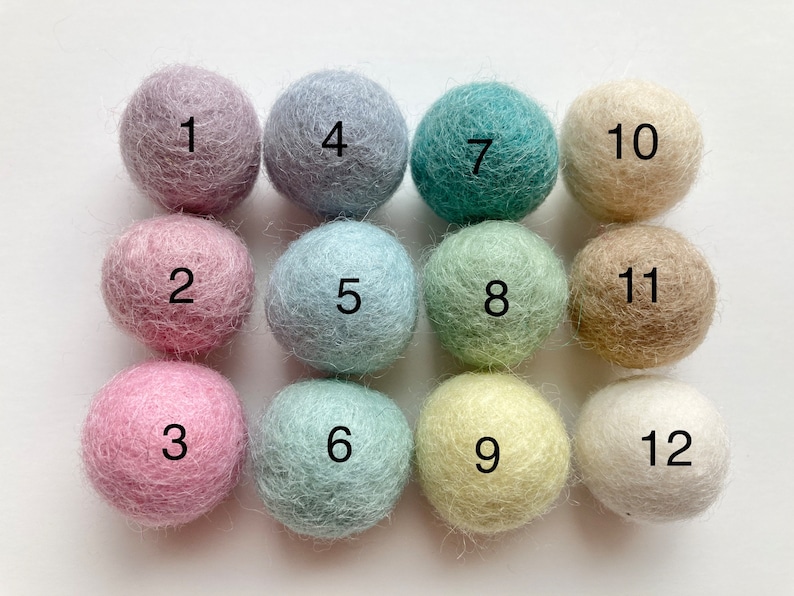 May include: Twelve felt balls in various pastel colors, numbered 1 through 12.