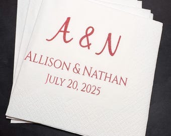 May include: White paper napkins with red text. The napkins are stacked and feature the names "Allison & Nathan" and the date "July 20, 2025" along with the initials "A & N".