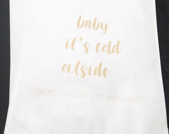 May include: White paper gift bags with gold lettering that reads "baby it's cold outside" and "Thank you for celebrating baby Walker".