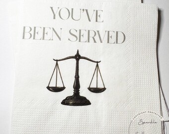 May include: White paper napkins with a printed design. The napkins feature the text "YOU'VE BEEN SERVED" above a black scale illustration. The napkins are textured and have a copyright mark.